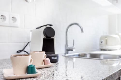 un bancone della cucina con due tazze di caffè di Casa da Vila a Vila do Bispo