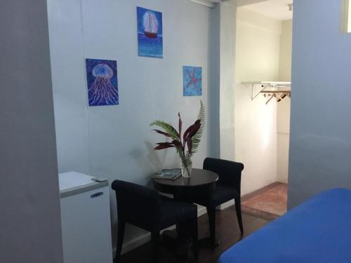 a dining room with a table and chairs and paintings at Harbour Vista Inn in Castries