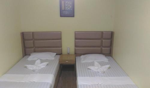 two beds in a small room with white sheets at Meaco Royal Hotel - Plaridel in Plaridel
