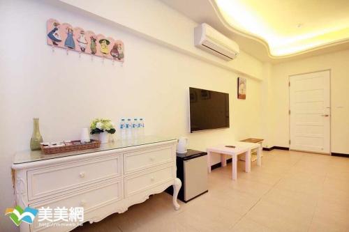 a living room with a dresser and a tv at 來嘉小棧 in Chiayi City