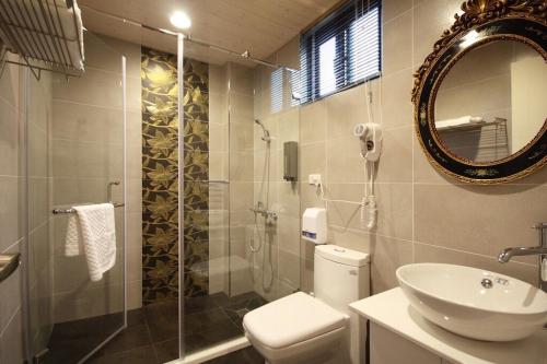 a bathroom with a toilet and a sink and a mirror at 來嘉小棧 in Chiayi City