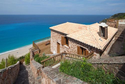 a stone house with a view of the ocean at Beyond Villas in Agios Nikitas