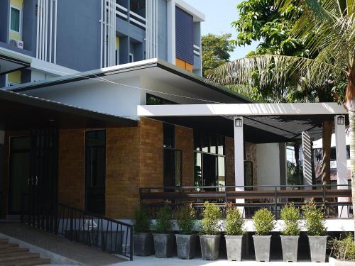 a building with awning and potted plants in front of it at Pimann Place Hotel in Chiang Rai