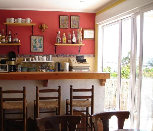 un bar dans un restaurant avec des murs et des chaises rouges dans l'établissement Pensión El Hidalgo, à Calp