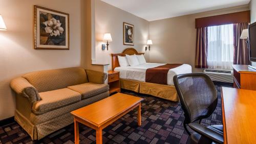 a hotel room with a bed and a couch at Best Western Longview in Longview