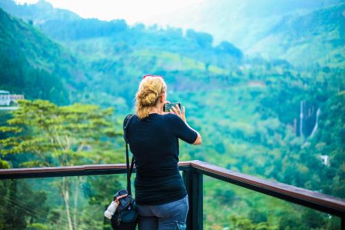 a woman taking a picture of the mountains at Oak Ray Tea Bush in Ramboda