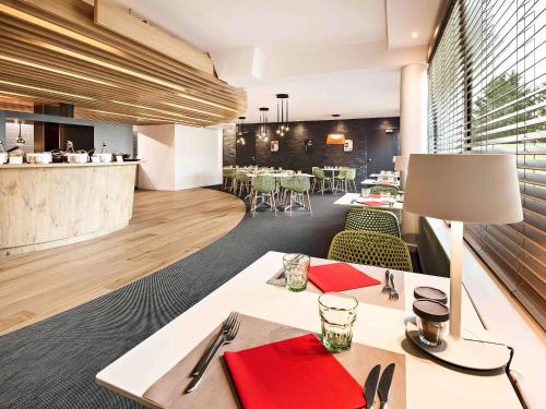 a dining room with a table with red napkins at ibis Site du Futuroscope in Chasseneuil-du-Poitou