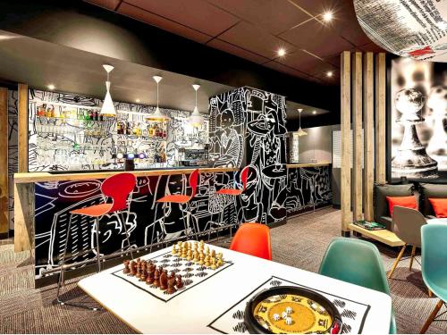 a restaurant with a wall covered in graffiti at ibis Site du Futuroscope in Chasseneuil-du-Poitou