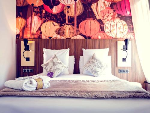 a bedroom with a bed with paper lanterns on it at Mercure Lyon Centre Plaza République in Lyon