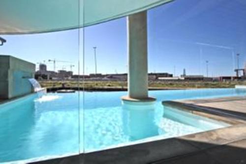 a swimming pool in a building with blue water at 702 Canal Quays in Cape Town