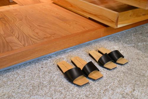 a group of knives on the floor next to a wooden table at 滔々 御崎 町家の宿 toutou Onzaki Machiya no Yado in Kurashiki
