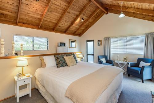 a bedroom with a bed and a desk and a chair at Harbour View Cottage Bay of Islands in Opua