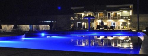 a swimming pool with blue lighting in front of a building at Lagoon beach resort in Gitagun
