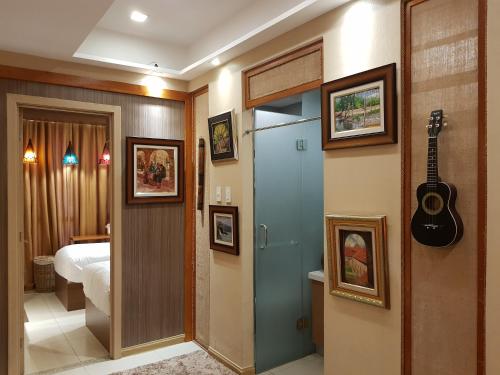 um quarto de hotel com uma guitarra na parede em Stay Amare Residences Malate em Manila