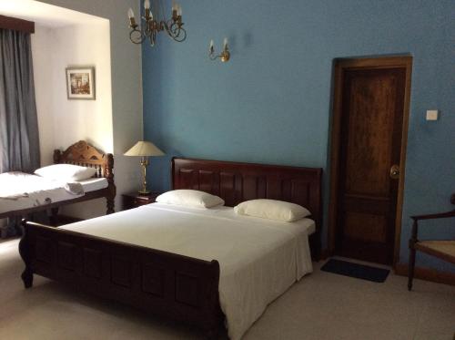 a bedroom with a large bed and blue walls at Hotel Mount Pleasant in Bandarawela