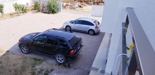 two cars parked in a parking lot next to a building at Apartment Vila Mirela in Krimovice