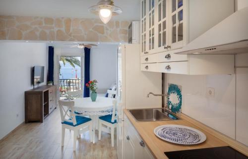 a kitchen with a sink and a table with chairs at Podgora City Center in Podgora