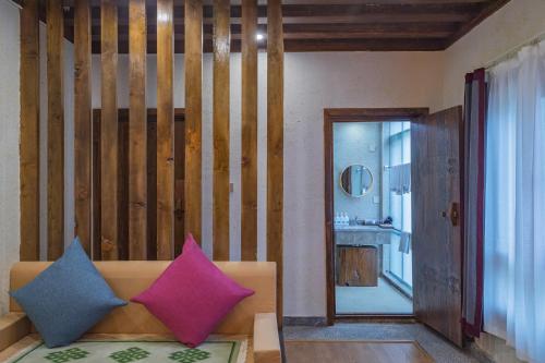 a living room with a couch with colorful pillows on it at Arro Khampa By Zinc Journey Shangri-la in Shangri-La