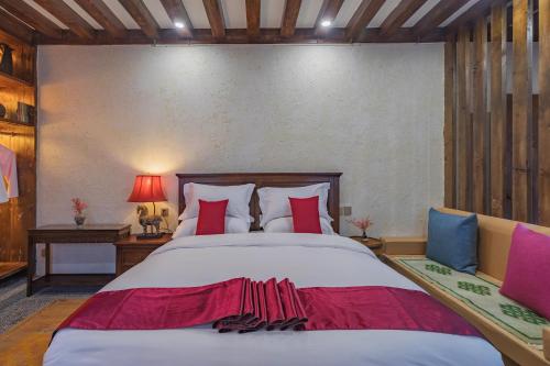 a bedroom with a large bed with red and blue pillows at Arro Khampa By Zinc Journey Shangri-la in Shangri-La