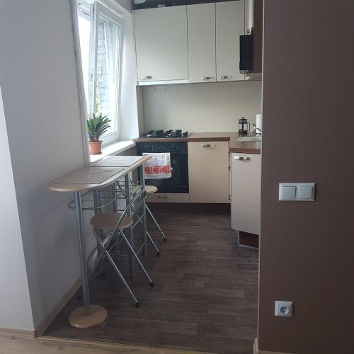 a kitchen with white cabinets and a table and chairs at B-Est Lilleküla Apartment in Tallinn