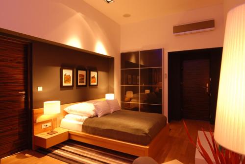 a bedroom with a bed and two lamps in it at Ivana Hotel in Oradea