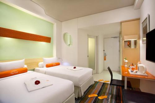 a hotel room with two beds and a desk at HARRIS Hotel & Convention Festival Citylink Bandung in Bandung