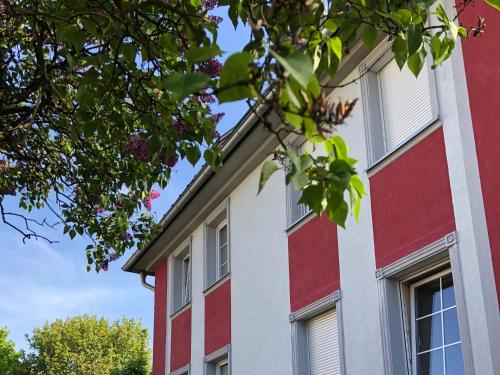 un bâtiment rouge et blanc avec des arbres au premier plan dans l'établissement Art Apartament, à Zielona Góra