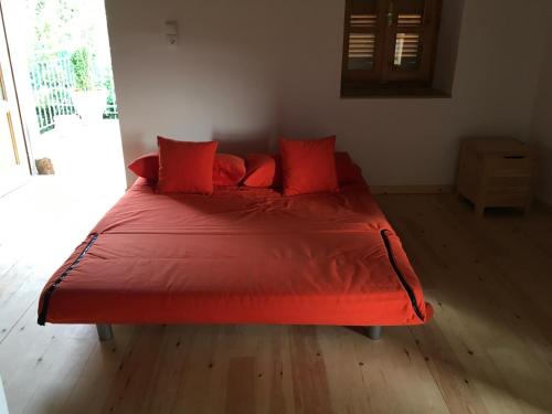 a red bed with red pillows in a bedroom at Nefeli in Tséria