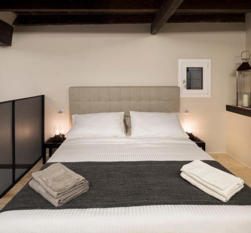 a bedroom with a large bed with two towels on it at Borgo De Chiari in Bologna
