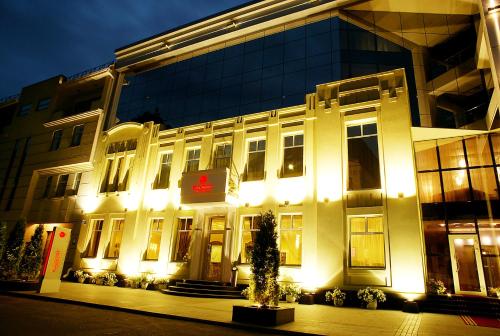 un edificio iluminado con un cartel delante en Park Hotel, en Dnipro