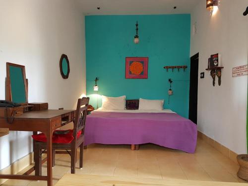 a bedroom with a bed and a desk and a table at Inn Seventh Heaven in Pushkar
