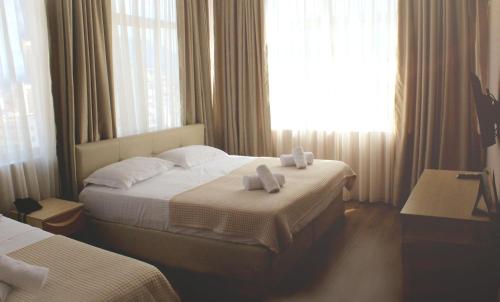a hotel room with two beds with towels on them at Signature Idea hotel in Tirana