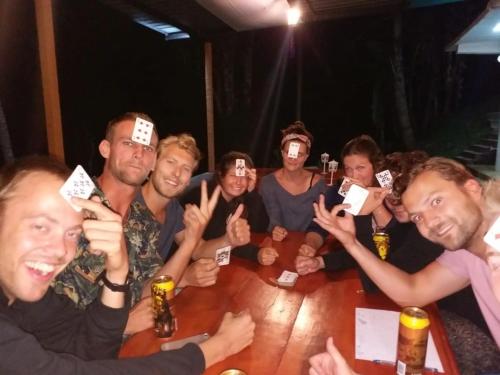 a group of people sitting around a wooden table at Ella Escapade Hostel in Ella