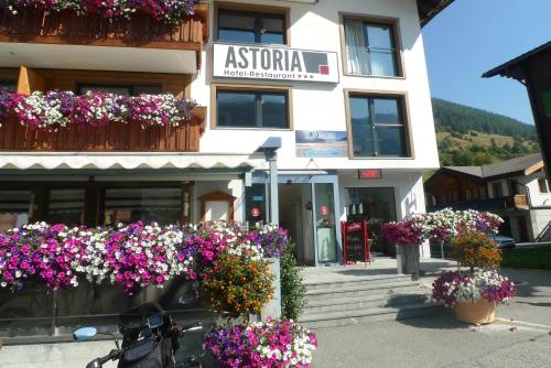 a building with flowers in front of it at Hotel Astoria in Ulrichen