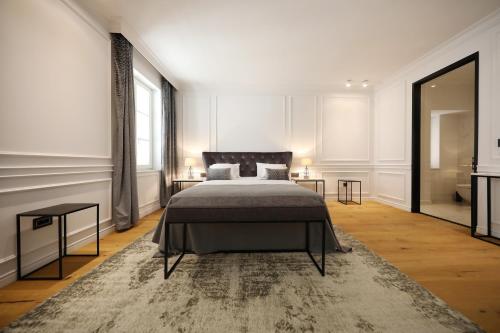 1 dormitorio con 1 cama grande y 2 mesas en Greta Residence, en Zadar