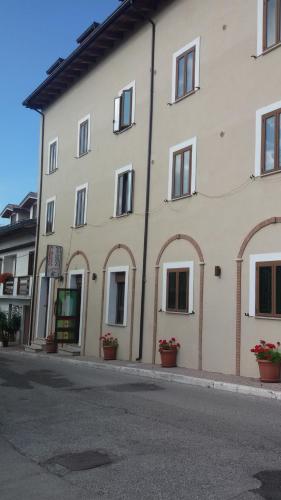a large white building with windows on a street at Albergo Il Cacciatore in Ovindoli