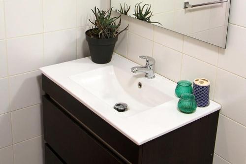 a white sink in a bathroom with a plant at Historical Porto/Gaia Apartment in Porto