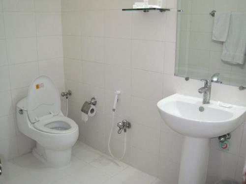 a white toilet sitting next to a sink in a bathroom at Royalton Hotel Rawalpindi in Rawalpindi