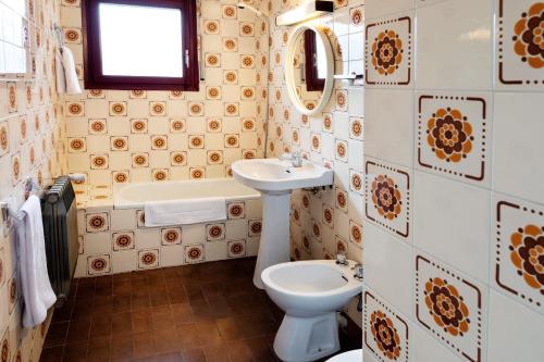 a bathroom with a sink and a toilet and a tub at Duc Allotjament in La Seu d'Urgell