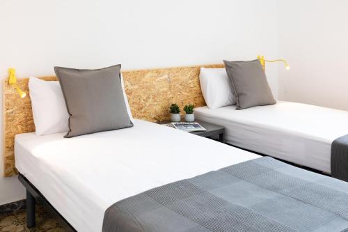 ラ・セウ・ドゥルジェイにあるDuc Allotjamentのベッド2台が隣同士に設置された部屋です。