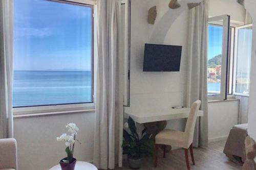 a living room with a desk and a large window at Hotel Marinella in Marciana Marina