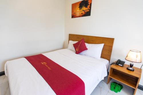 a bedroom with a bed with a red and white blanket at Hoang Phuc Hotel in Thu Dau Mot