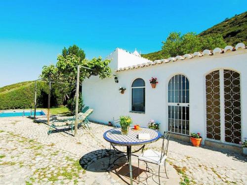 ein kleines weißes Haus mit einem Tisch und einer Terrasse in der Unterkunft Belvilla by OYO Casa Torcalillos in La Joya