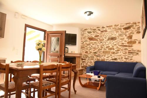ein Wohnzimmer mit einem Tisch und einem blauen Sofa in der Unterkunft Villa Anna in Balíon