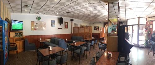 ein Restaurant mit Tischen und Stühlen in einem Zimmer in der Unterkunft Hostal Almenara in Paterna del Madera