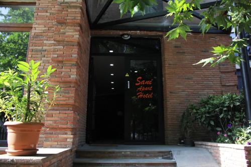 a brick building with a door with a sign on it at Sani Apart Hotel in Tbilisi City