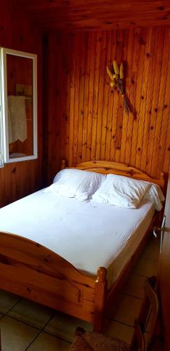 une chambre en bois avec un lit avec un ventilateur dans l'établissement Chalet Saint Julien en Born, à Saint-Julien-en-Born