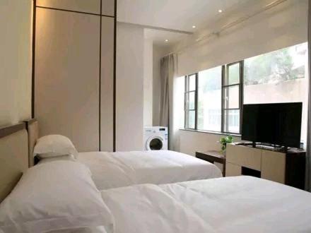 a bedroom with two beds and a flat screen tv at Shenzhen Mint Apartment in Shenzhen