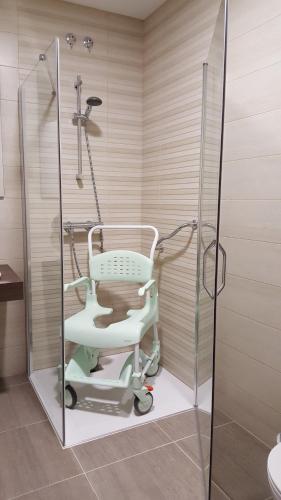 a shower with a chair in a bathroom at Apartmentos El Alfar del Sacramento in Toledo