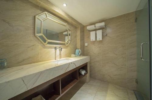 a bathroom with a sink and a mirror at Shenzhen Mint Apartment in Shenzhen